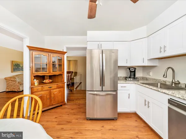 a kitchen with granite countertop a refrigerator a stove top oven and sink