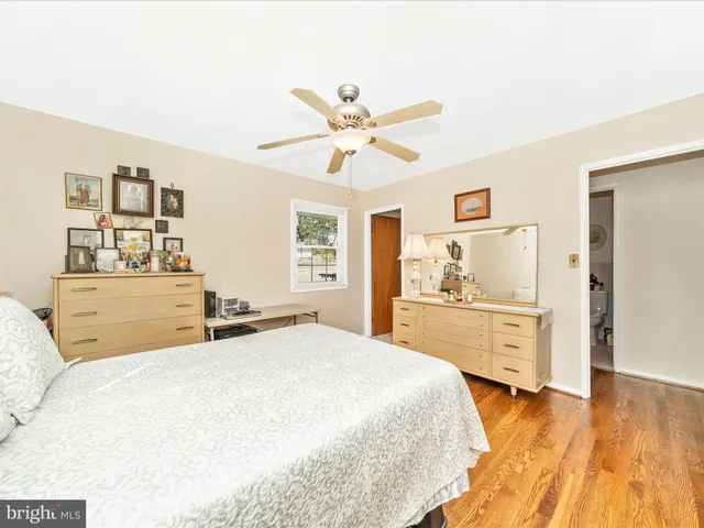 a spacious bedroom with a large bed and chandelier
