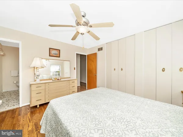 a spacious bedroom with a large bed and chandelier