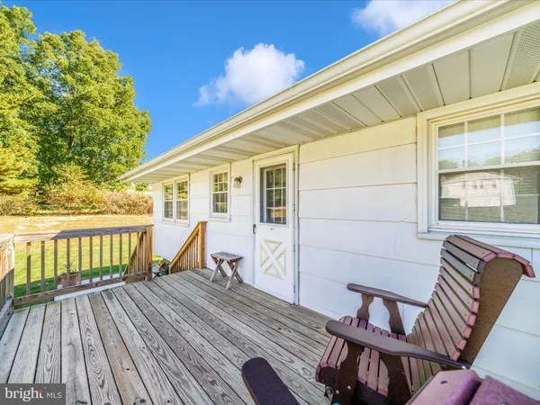 a balcony with wooden floor table and chairs