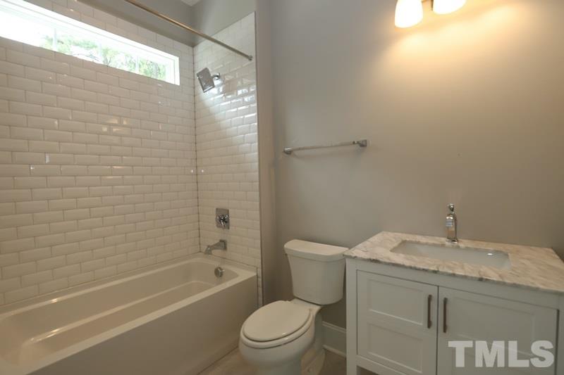 7200 Grist Mill Road Raleigh, NC 27615 - Photo 14 of 25 a bathroom with a granite countertop toilet a sink and bathtub