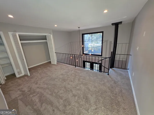 an empty room with windows and stairs