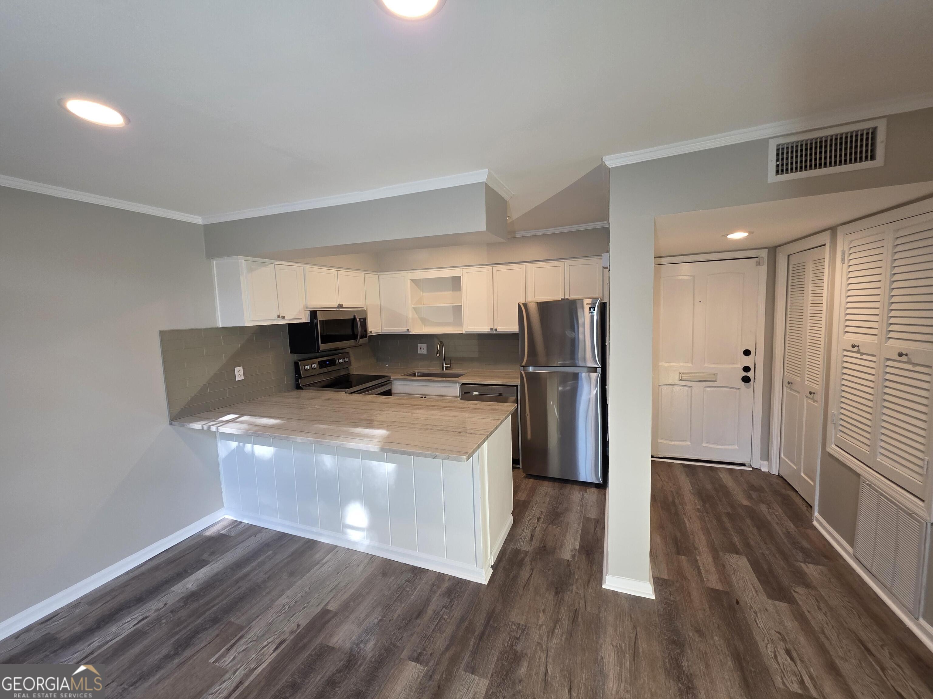 123 Elysian Way Northwest Atlanta, GA 30327 - Photo 5 of 18 a view of kitchen with stainless steel appliances granite countertop a refrigerator a sink dishwasher a stove and white countertops with wooden floor