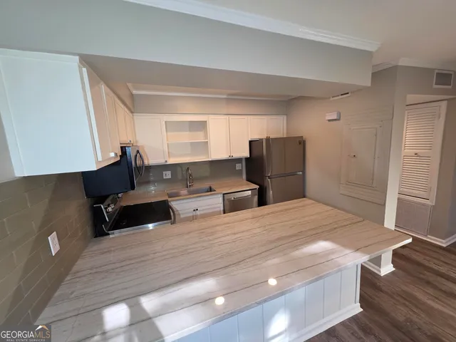 a living room with furniture and a refrigerator