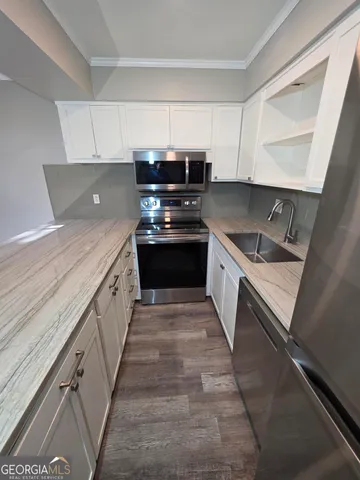 a kitchen with granite countertop a sink and stove top oven