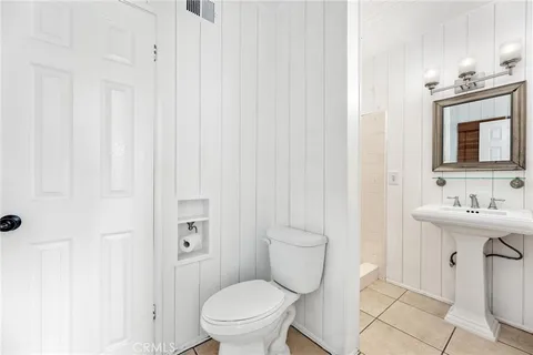 a bathroom with a toilet a sink a mirror and vanity