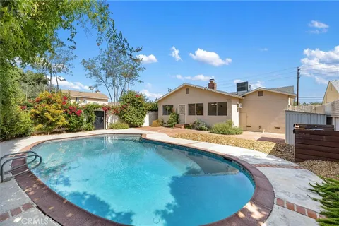 a view of a house with pool and sitting area