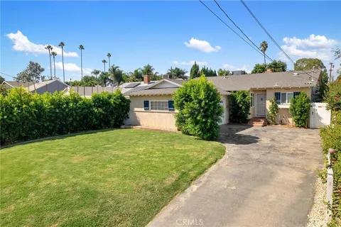 a front view of a house with a garden and plants