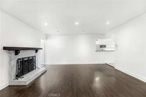 a view of a livingroom with wooden floor and a fireplace