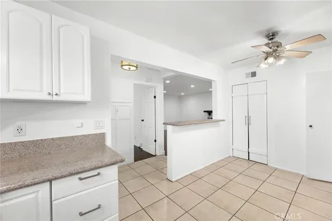 a kitchen with a refrigerator and white cabinets