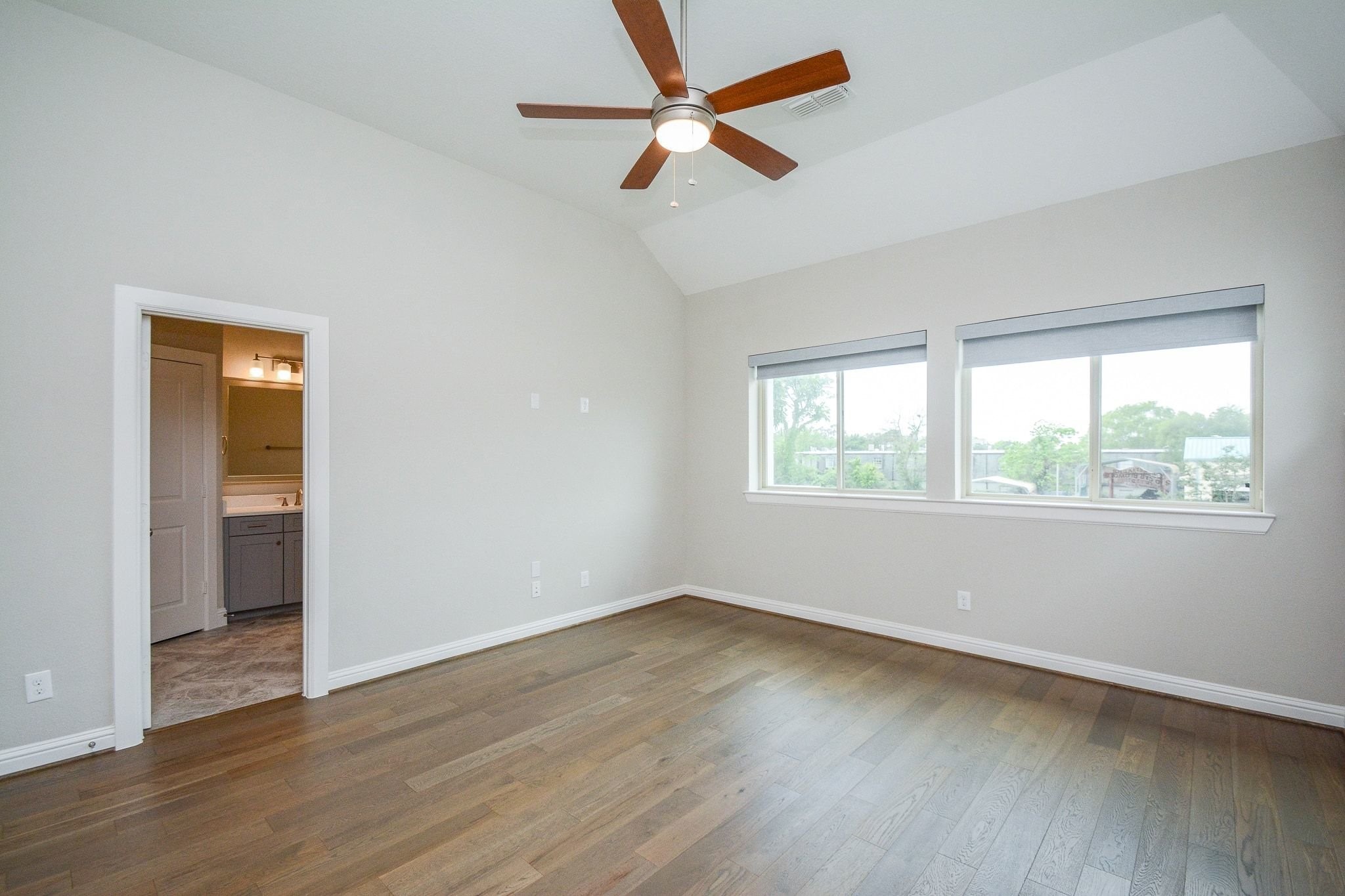 1407 Arkley Way Houston, TX 77055 - Photo 19 of 41 an empty room with wooden floor fan and windows