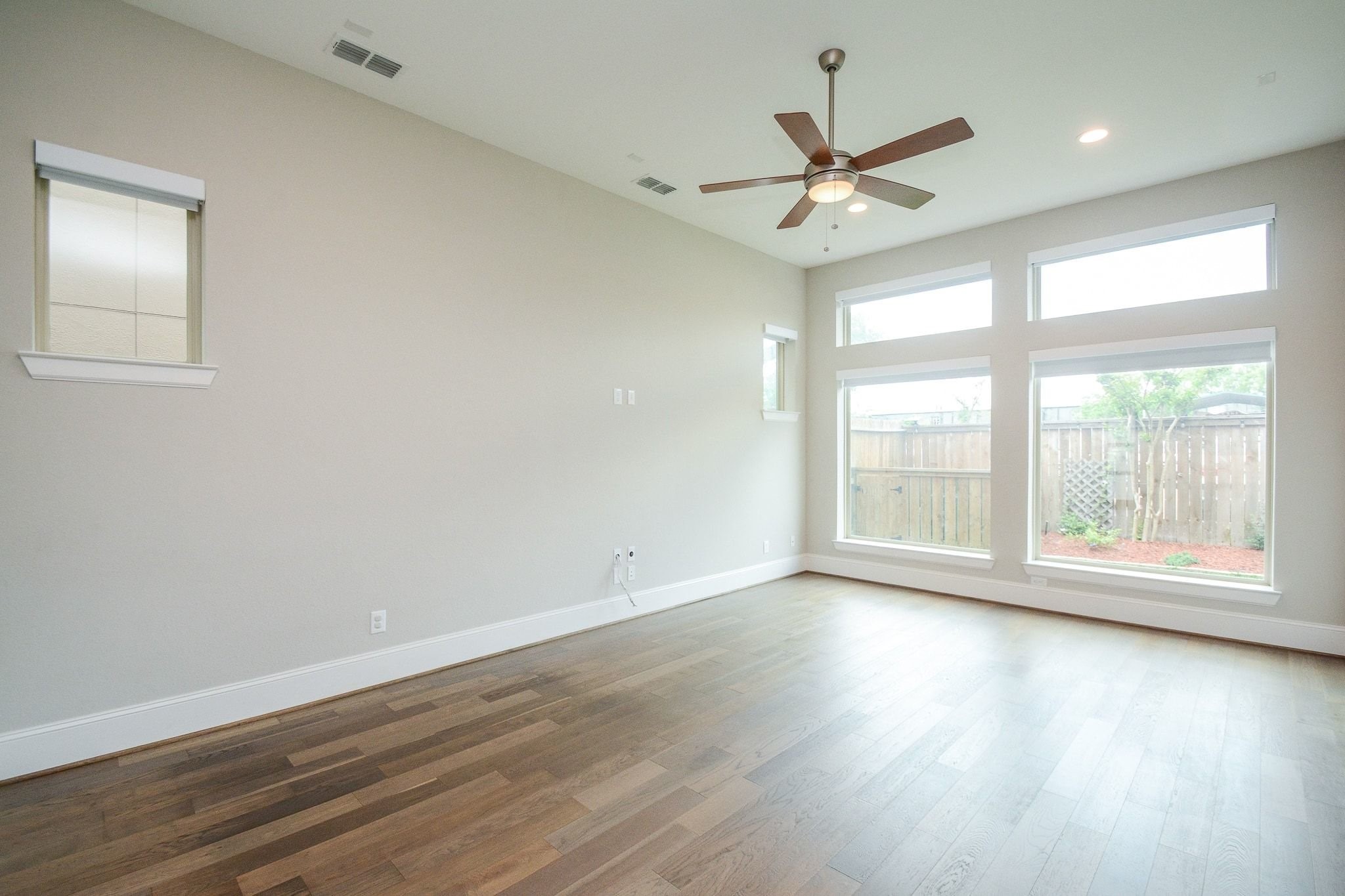 1407 Arkley Way Houston, TX 77055 - Photo 6 of 41 an empty room with wooden floor fan and windows
