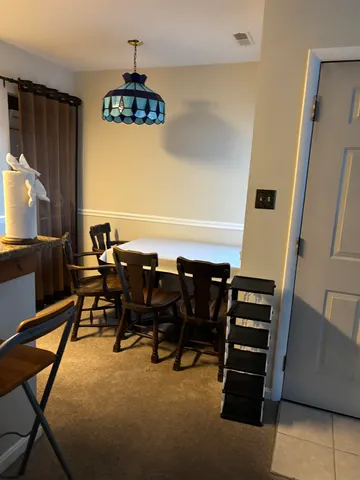 a view of a dining room with furniture and a chandelier