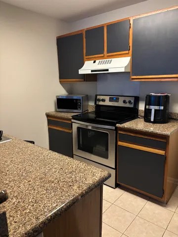 a kitchen with stainless steel appliances granite countertop a stove a sink and a microwave