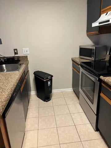 a kitchen with a stove a sink and a microwave