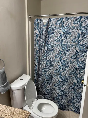 a bathroom with a toilet and a shower curtain