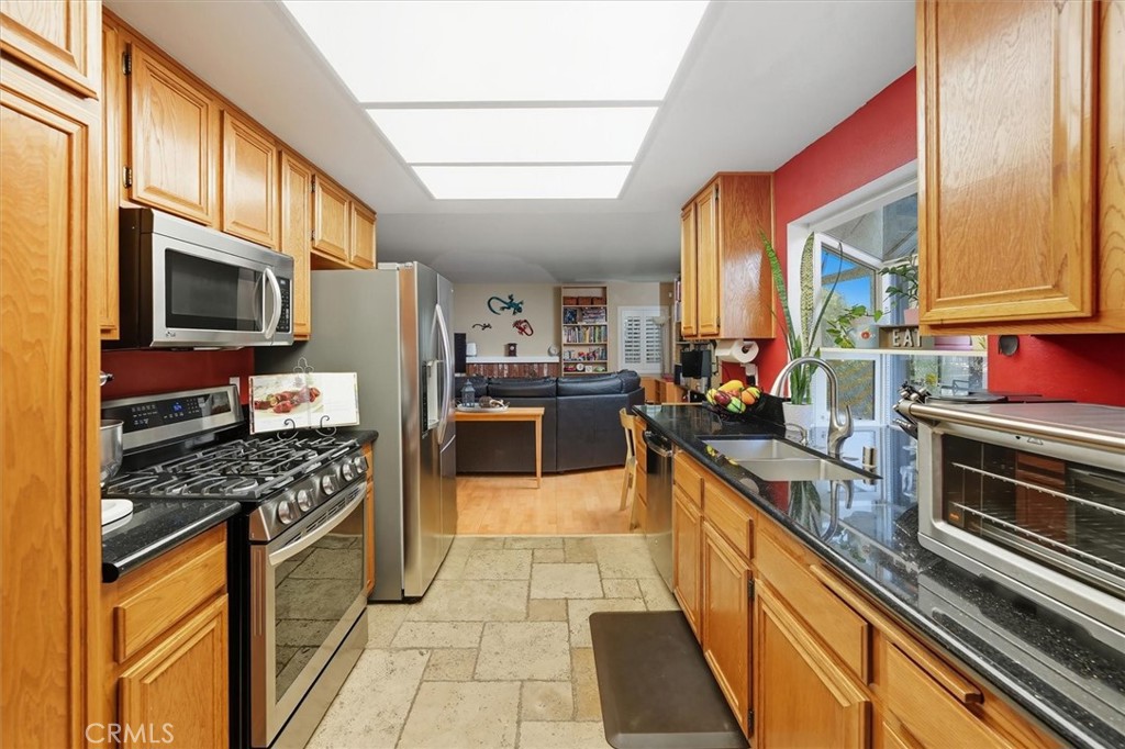 31347 Quail Valley Road Castaic, CA 91384 - Photo 8 of 41 a kitchen with stainless steel appliances kitchen island granite countertop a stove top oven a sink dishwasher a dining table and chairs with wooden floor