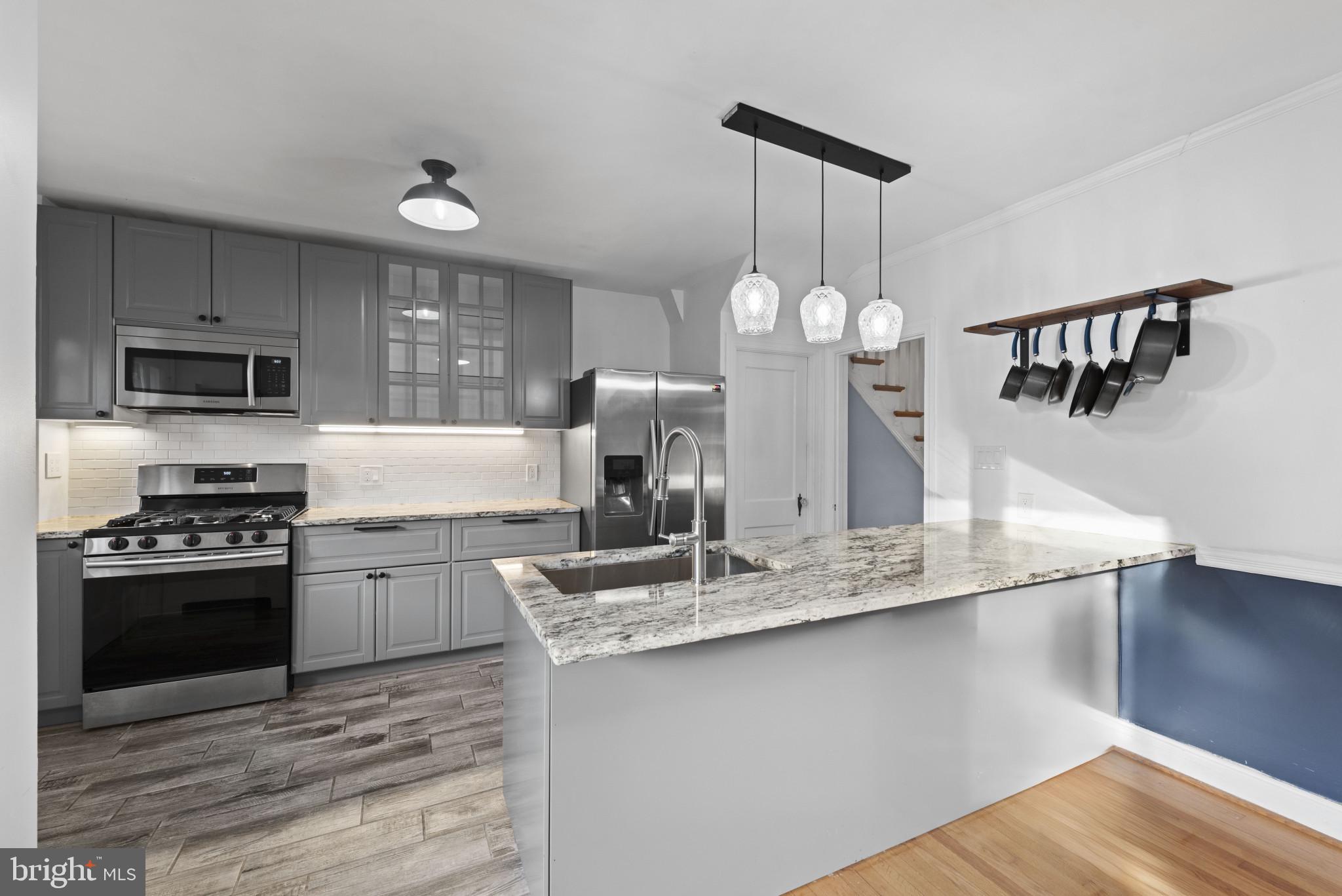 3712 Monterey Road Baltimore, MD 21218 - Photo 14 of 40 a kitchen with kitchen island granite countertop a sink cabinets and stainless steel appliances