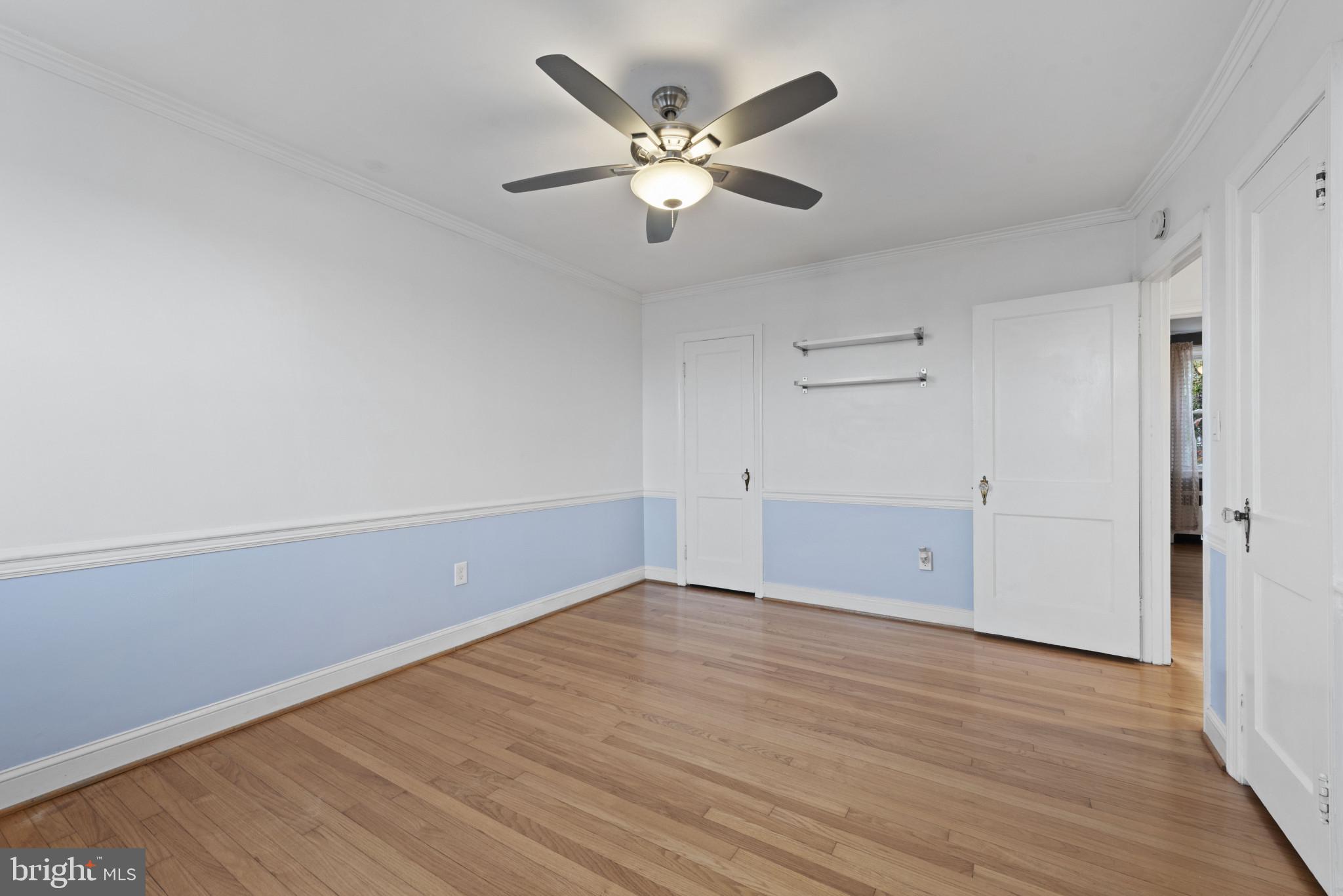 3712 Monterey Road Baltimore, MD 21218 - Photo 19 of 40 an empty room with wooden floor and ceiling fan