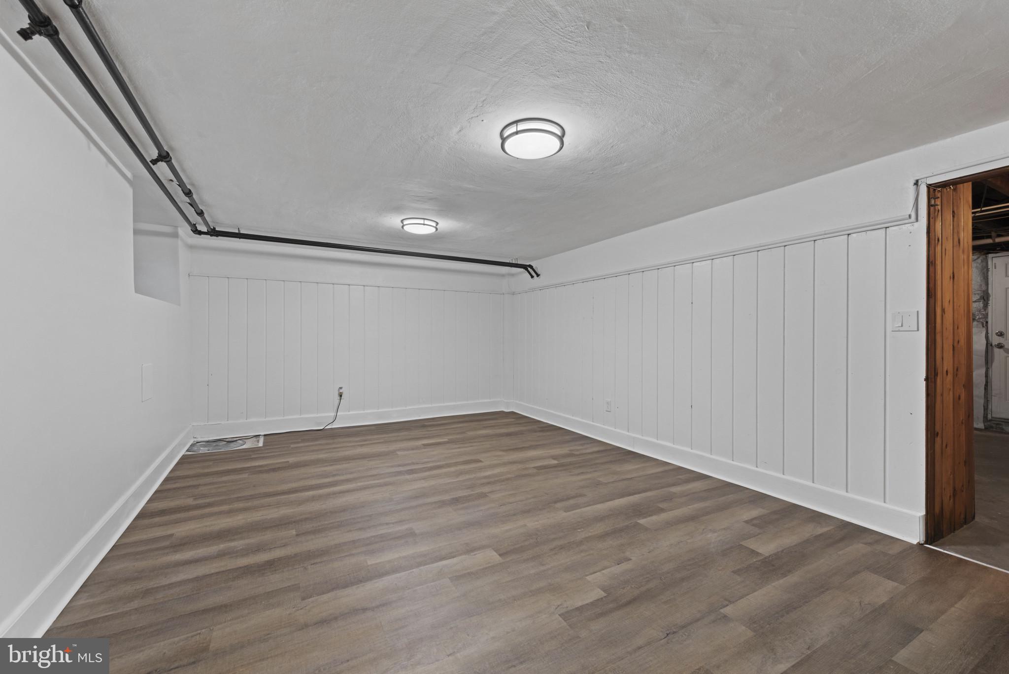 3712 Monterey Road Baltimore, MD 21218 - Photo 28 of 40 a view of an empty room with wooden floor and a window