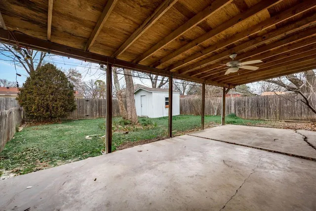 a view of a backyard with wooden fence