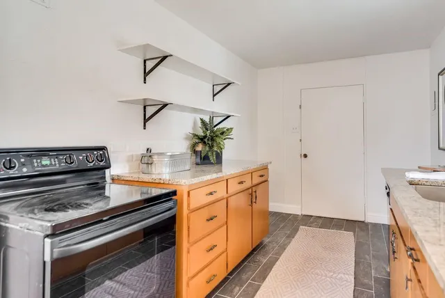a kitchen with stainless steel appliances a stove and white cabinets