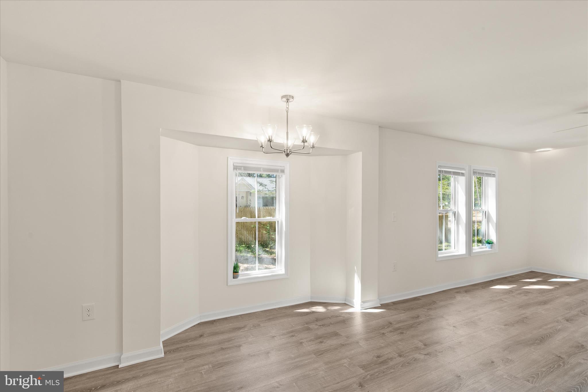 26465 Mason Webster Road Princess Anne, MD 21853 - Photo 14 of 56 an empty room with windows and chandelier