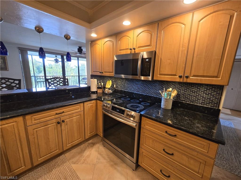 7119 Lakeridge View Court, Unit 302 Fort Myers, FL 33907 - Photo 17 of 44 a kitchen with granite countertop a sink stainless steel appliances wooden floor and a counter top space