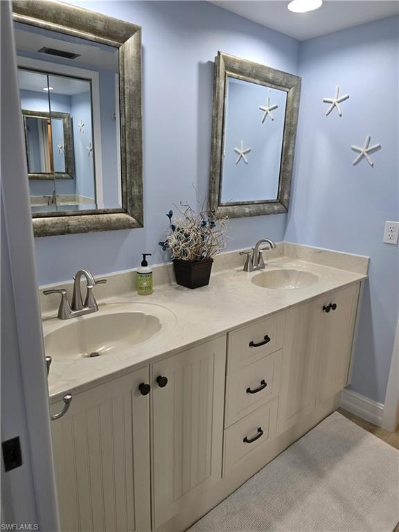 7119 Lakeridge View Court, Unit 302 Fort Myers, FL 33907 - Photo 36 of 44 a bathroom with a double vanity sink and mirror