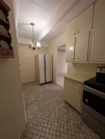 a kitchen with a stove cabinets and a refrigerator