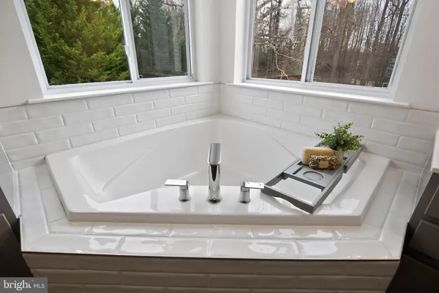 a spacious bathroom with a double vanity sink large mirror and a bathtub
