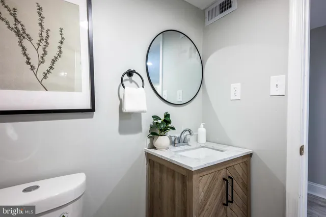 a bathroom with a toilet sink and mirror