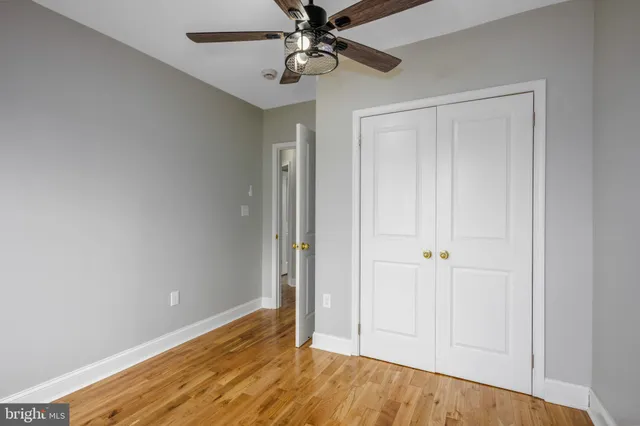 a view of room with hardwood floor and ceiling fan