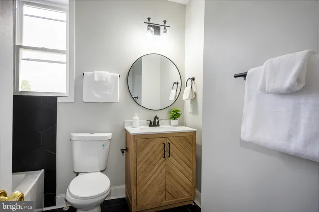 a bathroom with a toilet a sink and a mirror