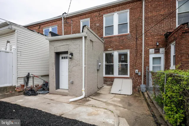 a view of a brick house with large windows and a table and chairs