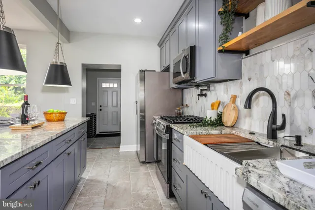 a kitchen with granite countertop a sink stainless steel appliances and cabinets