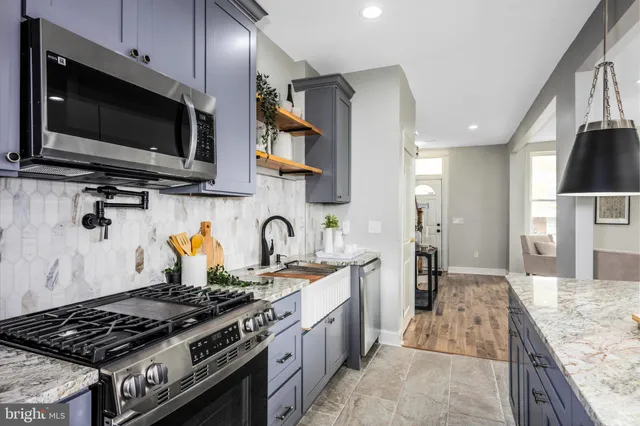 a kitchen with stainless steel appliances granite countertop a sink stove and refrigerator