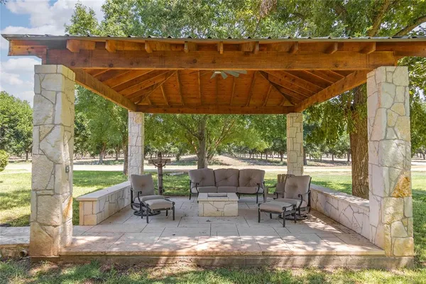 a view of a patio with table and chairs under an umbrella next to a yard