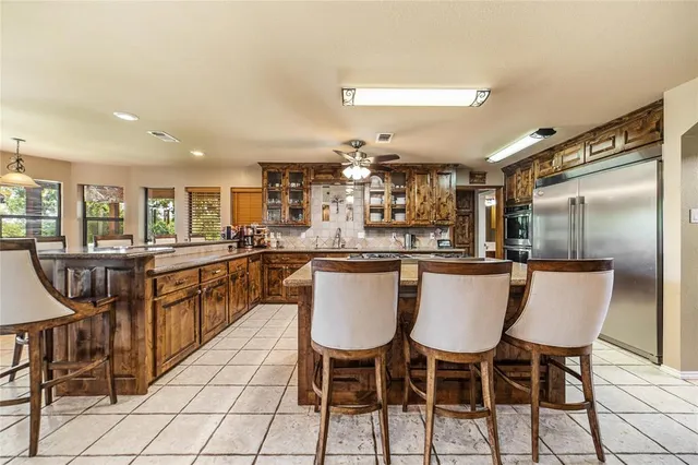 a kitchen with stainless steel appliances granite countertop a kitchen island a table and chairs