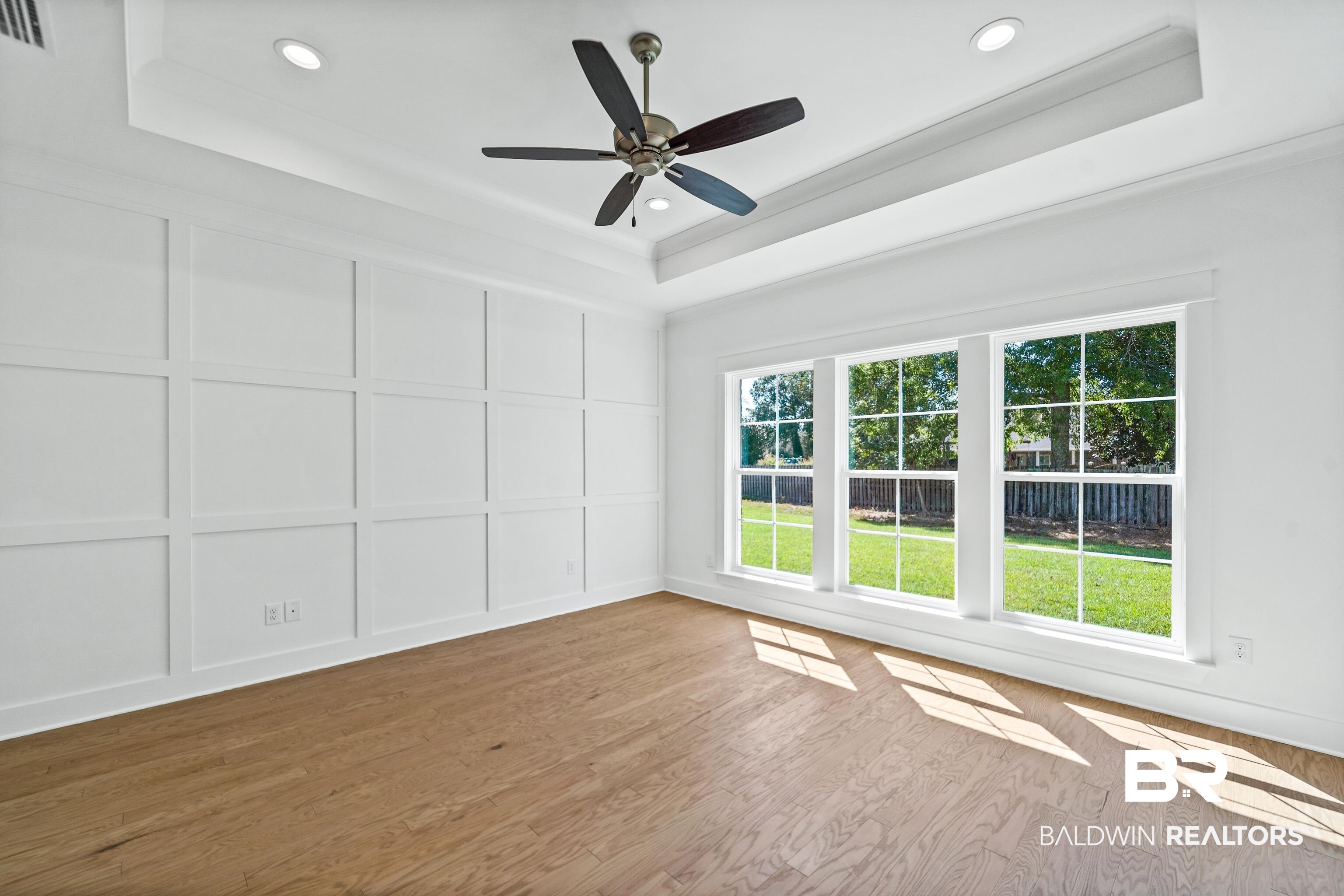 25927 Capra Court Daphne, AL 36526 - Photo 16 of 37 Unfurnished room with a raised ceiling, ornamental molding, ceiling fan, and hardwood / wood-style flooring
