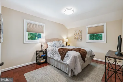 a bedroom with a bed a mirror and a window