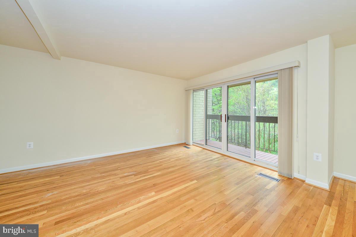 11187 Saffold Way Reston, VA 20190 - Photo 11 of 27 a view of an empty room with wooden floor and a window
