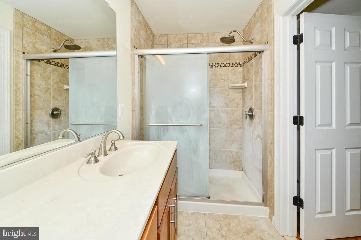 11187 Saffold Way Reston, VA 20190 - Photo 12 of 27 a bathroom with a shower a sink and a mirror