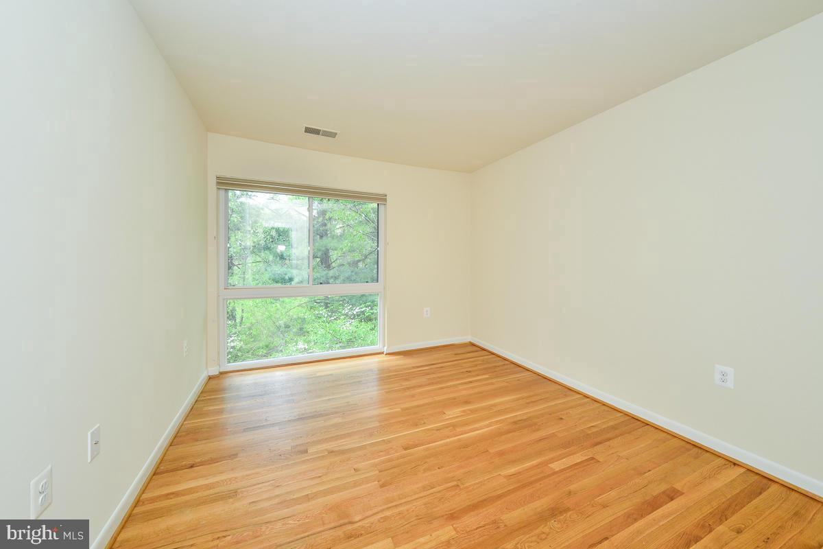 11187 Saffold Way Reston, VA 20190 - Photo 19 of 27 a view of an empty room with wooden floor and a window