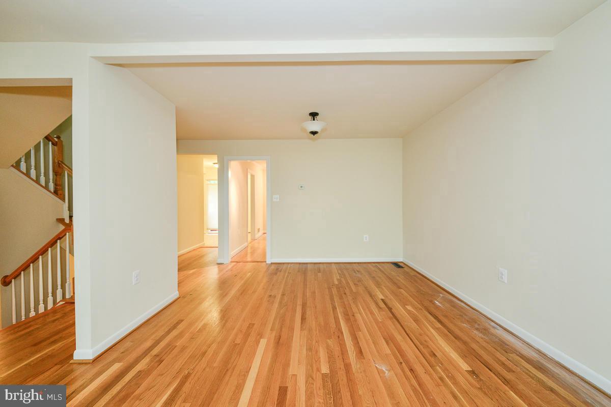 11187 Saffold Way Reston, VA 20190 - Photo 3 of 27 a view of an empty room with wooden floor and a window
