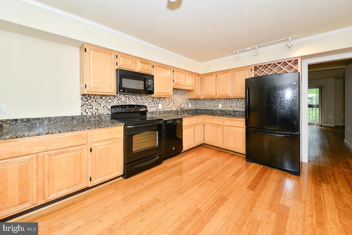 11187 Saffold Way Reston, VA 20190 - Photo 6 of 27 a kitchen with granite countertop a refrigerator stove top oven and sink