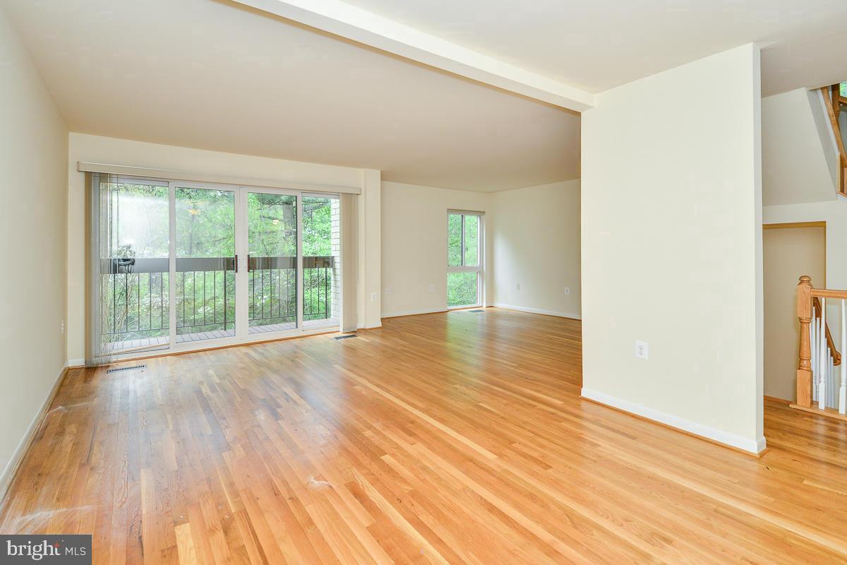 11187 Saffold Way Reston, VA 20190 - Photo 9 of 27 an empty room with wooden floor and windows