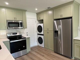 320 Ralph Street, Unit D White Settlement, TX 76108 - Photo 2 of 7 a kitchen with a refrigerator and a stove top oven with wooden floor