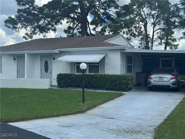 a car parked in front of a white house