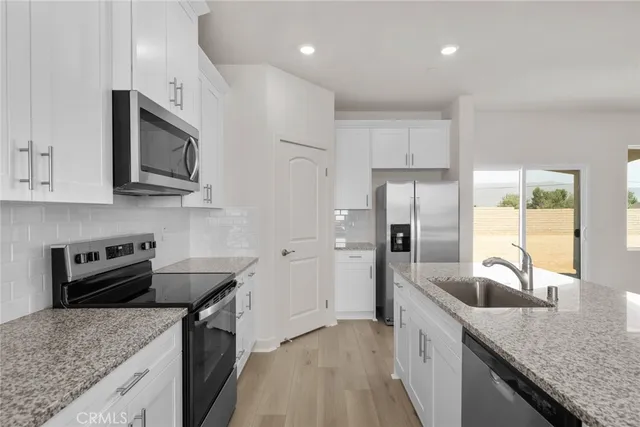 a kitchen with granite countertop kitchen island a sink appliances and cabinets
